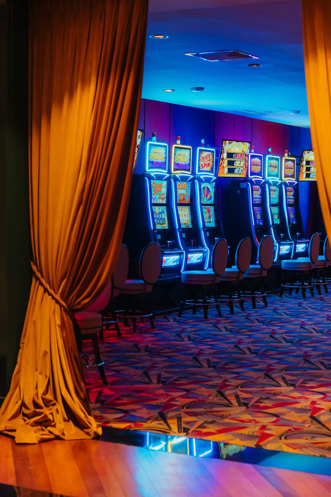 Sala de juego de Casino Dominic Cortinas doradas abriéndose a la sala de juego de Casino Dominic